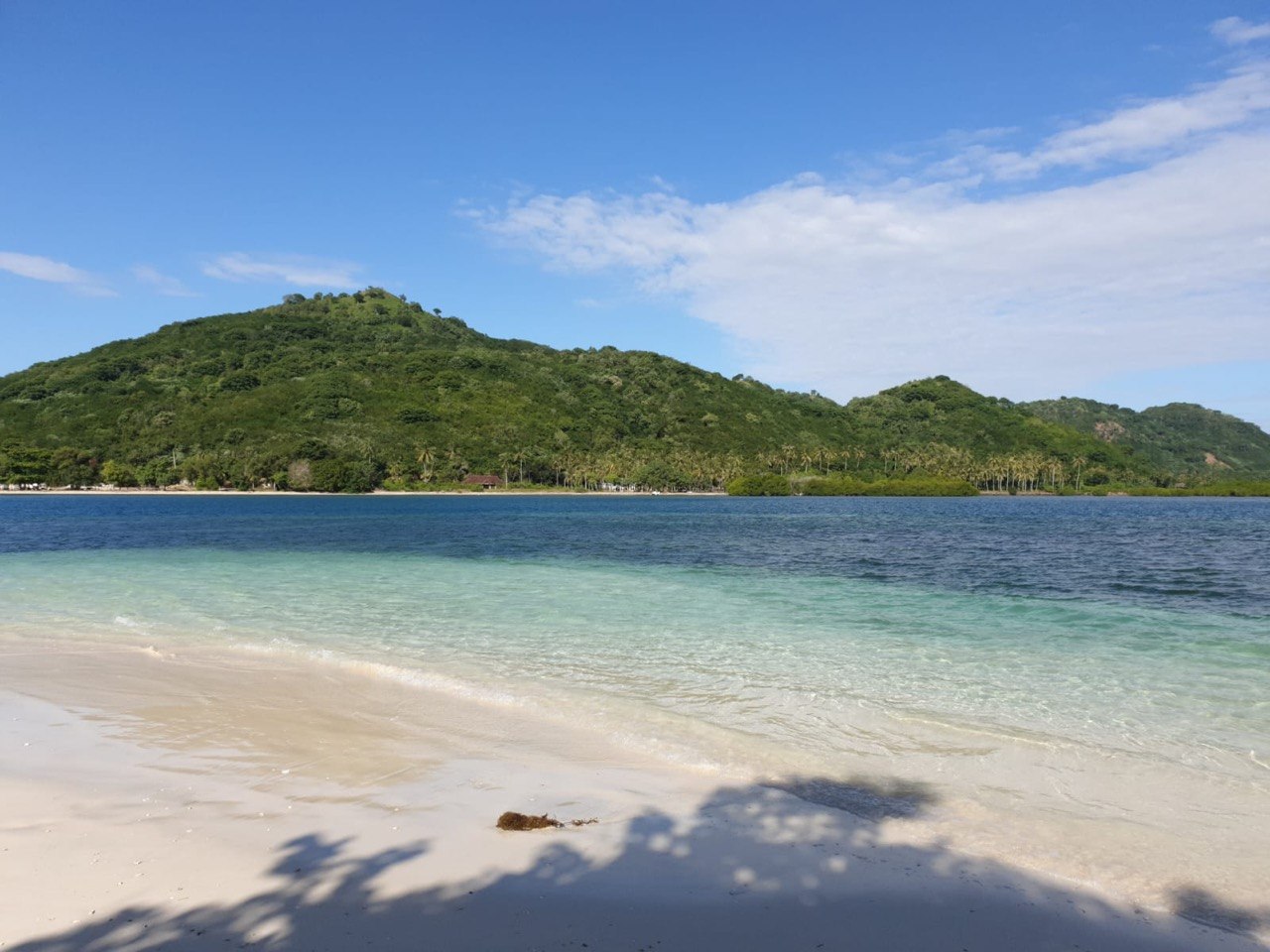 White-sand beach with mountain backdrop